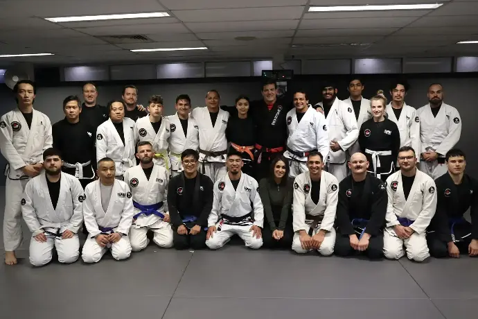 Group photo of Alpha Jiu Jitsu Academy team including instructors, students, and special guests, showcasing camaraderie and dedication to Brazilian Jiu Jitsu training.